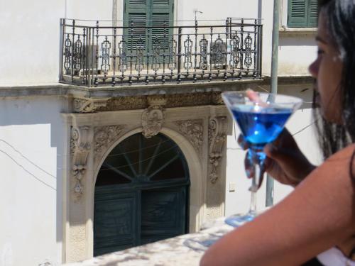 Cannole拉斯特迪可普若旅馆的一位在建筑物前拿着酒杯的女人