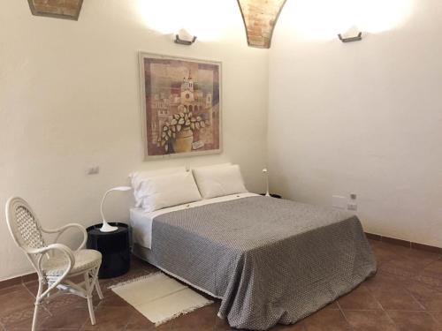 福利尼奥Residenza Galligari的卧室配有一张床,墙上挂有绘画作品