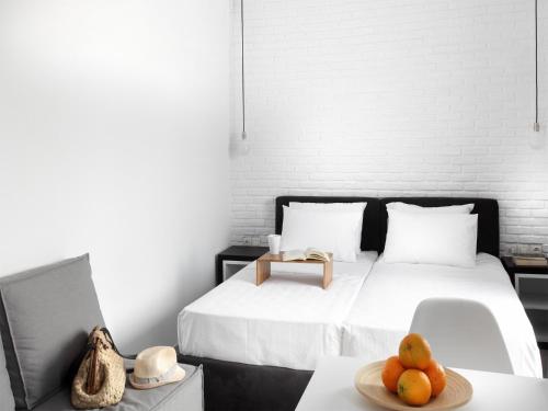 雅典雅典景致阁楼 - 01公寓的一间卧室,配有一张床上的床铺,桌上放着一碗水果