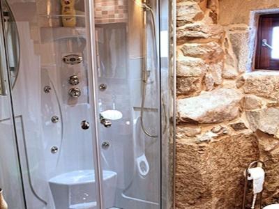 科巴罗Casa Noelmar的带淋浴的浴室(带石墙)