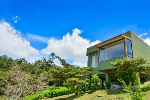 蒙泰韦尔德哥斯达黎加哥斯达黎加彩虹谷山林小屋的一座绿树成荫的山丘上的房子