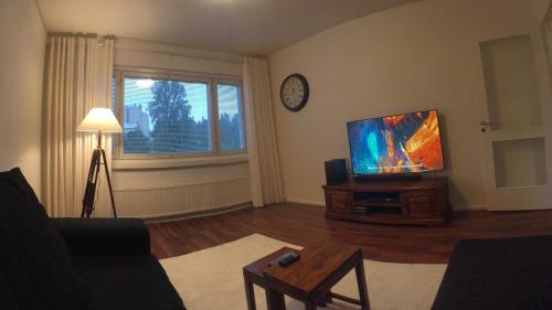 库奥皮奥City Apartment Sairaalakatu的客厅配有平面电视和桌子。