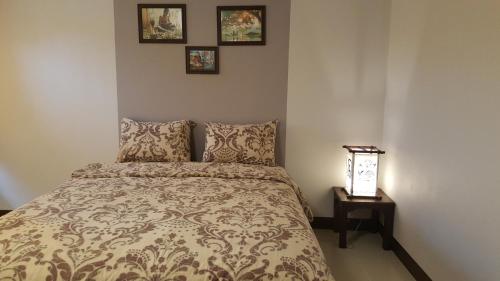 素可泰老城精品屋旅馆的卧室配有一张床,墙上挂有两张照片