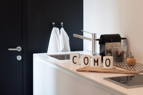 科莫Suite Juvara的厨房柜台配有水槽和阅读昏迷的标志