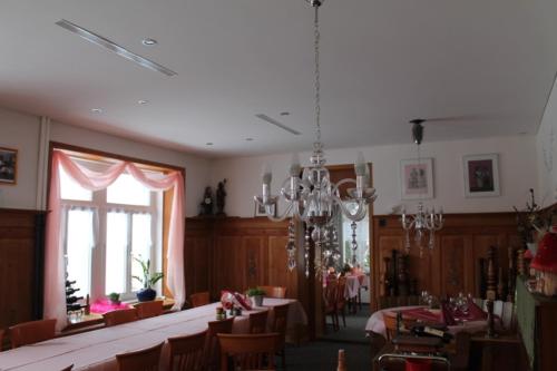 韦斯巴德贝尔韦达雷餐厅酒店的一间带桌椅和吊灯的用餐室