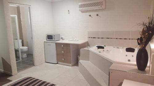 科夫斯港滨海湾汽车旅馆 的带浴缸、盥洗盆和卫生间的浴室
