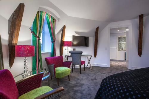 哥本哈根阿布萨隆丹恩斯克食客酒店的配有床、椅子和桌子的酒店客房