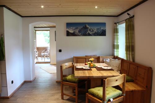 贝希特斯加登Landhaus Kranzbichl的一间带木桌和椅子的用餐室