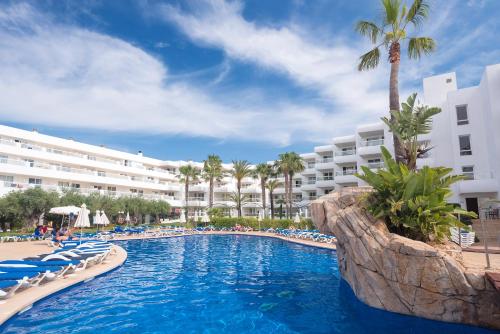 圣埃乌拉利亚热带花园公寓式酒店的一个带椅子的游泳池,一个度假胜地