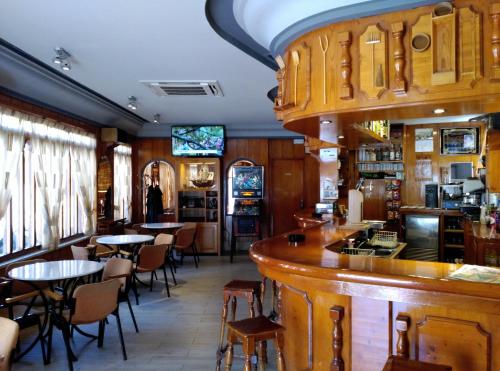 坎塔莱霍Hostal Romi的餐厅内的酒吧配有桌椅