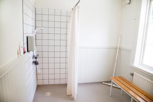 谢莱夫特奥Stiftsgården Hostel Skellefteå的带淋浴的浴室和长凳