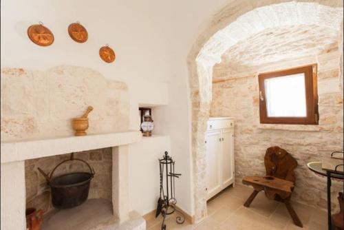 马丁纳弗兰卡Trullo Abbracciavento的客厅设有石制壁炉和窗户。