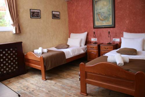 尼克希奇德拉戈维奇尼克希奇公寓酒店的红色墙壁客房的两张床