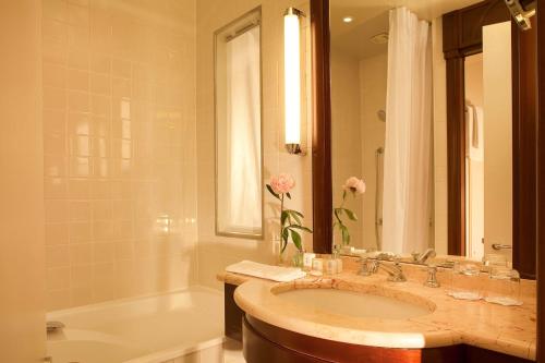 巴黎游乐场酒店的浴室配有盥洗盆、浴缸和盥洗盆