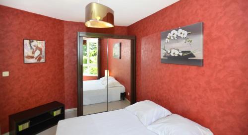 里昂Appart' Rachais的一间卧室设有红色墙壁、两张床和镜子