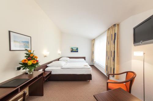 沃尔夫斯堡斯特耶斯基诺富姆酒店的配有一张床和一张书桌的酒店客房