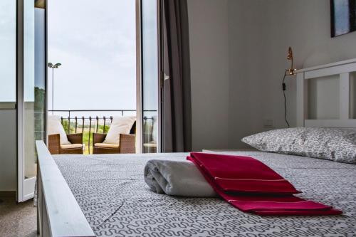 锡拉库扎Villa il Faro的一间卧室配有一张大床,上面有红色的毛巾