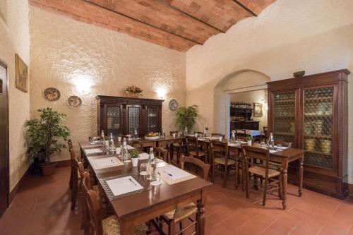 潘札诺Relais Fattoria Valle的大型用餐室配有木桌和椅子