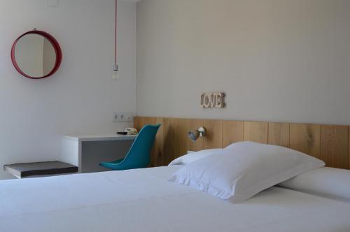 卡达克斯诺艾斯特乐斯酒店的一间卧室配有一张床、一张书桌和一面镜子