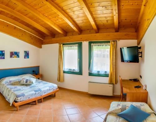 卡瓦伊翁韦罗内塞阿尔科尔农家乐的一间卧室设有一张床和木制天花板