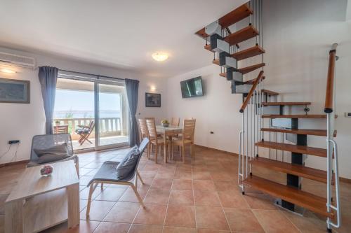 巴里克德拉加Seaside Apartment Barić Draga的客厅设有螺旋楼梯和桌椅