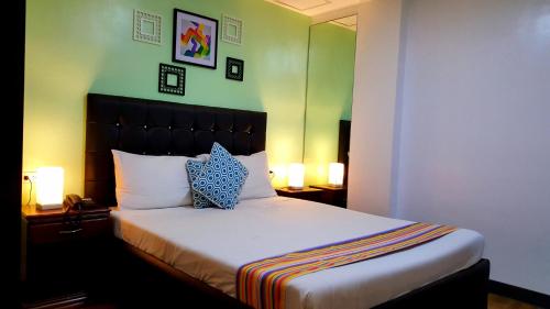 安吉利斯950公寓的一间卧室配有一张带两个枕头和两个灯的床。