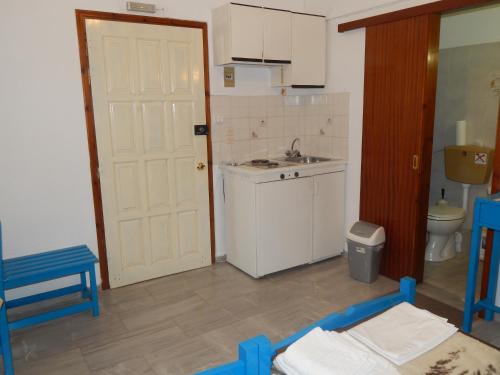 库卡里Dimitris studios的一个带水槽和白色门的小厨房