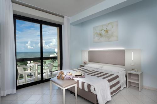 里乔内Hotel Carlton的一间卧室配有一张床,享有海景