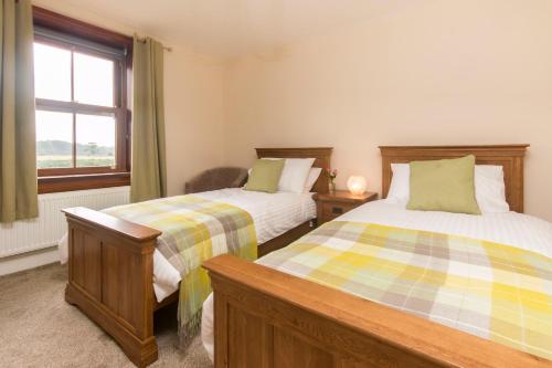 科克勒姆斯坦利住宿加早餐旅馆的一间卧室设有两张床和窗户。