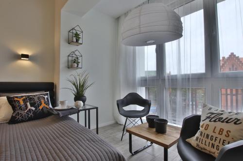 比得哥什兹博泽维里内克2号公寓的卧室配有1张床、1张桌子和1把椅子