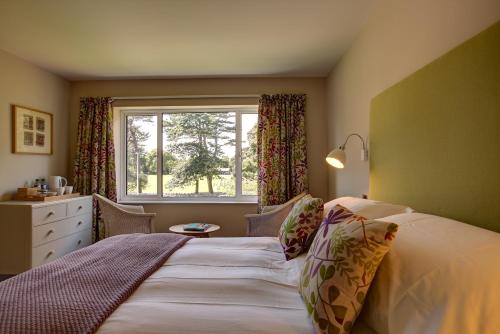 滨海韦斯顿公园旅馆的一间卧室设有一张大床和一个窗户。