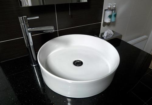 肯梅尔肯梅尔湾酒店的浴室设有黑色柜台上的白色水槽