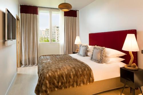 巴黎巴黎巴士底哥拉斯卡酒店的一间卧室设有一张大床和大窗户