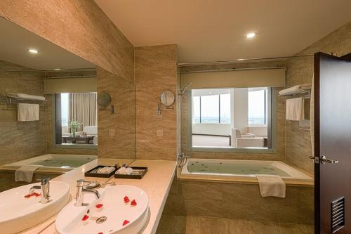 Kỳ Anh河静孟青大酒店的浴室配有2个盥洗盆、浴缸和淋浴。