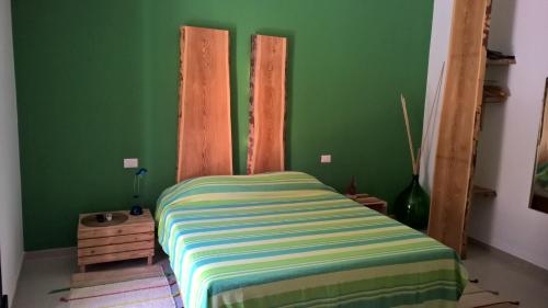 巴里拉万提诺住宿加早餐旅馆的一间卧室设有绿色的墙壁和一张带条纹床单的床