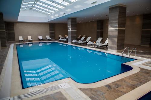 卡尔巴拉卡尔巴拉男爵酒店的酒店的大型游泳池配有桌椅