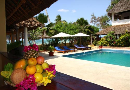 吉汶瓦布鲁马林度假酒店的游泳池畔的桌子上放上一碗水果