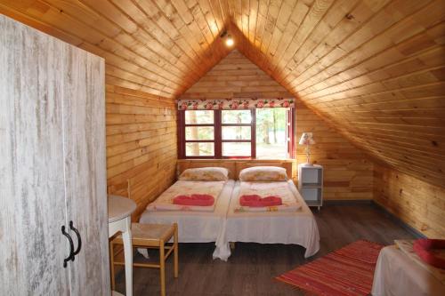 PērkoneVērbeļnieki的小木屋内一间卧室,配有两张床