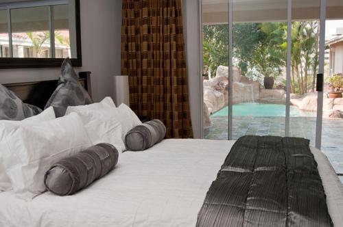 德班Rostalyn Guesthouse的一间卧室配有一张带两个枕头的床