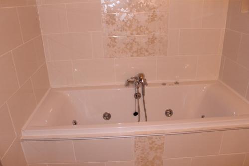 肯梅尔The Twelve Oaks的浴室设有带淋浴的白色浴缸。