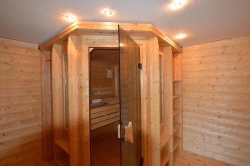 施塔特韦伦夕阳度假屋的一间设有木墙和玻璃门的桑拿浴室