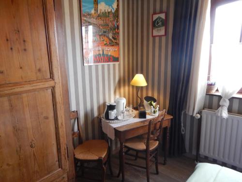蒙斯B&B La Chrysalide的配有桌椅和台灯的房间