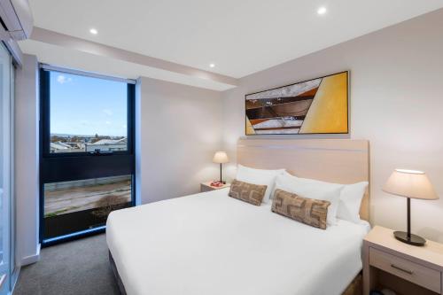 阿德莱德iStay Precinct Adelaide的卧室设有一张白色大床和大窗户