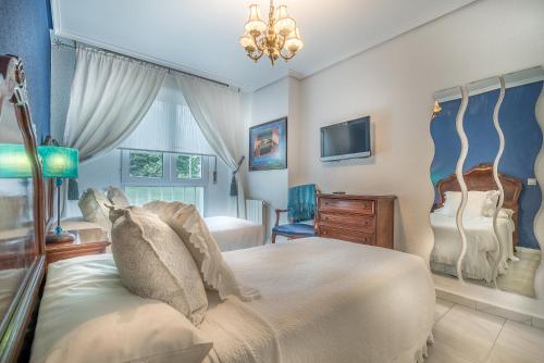 桑坦德拉斯布里萨公寓酒店的一间带大床和电视的卧室