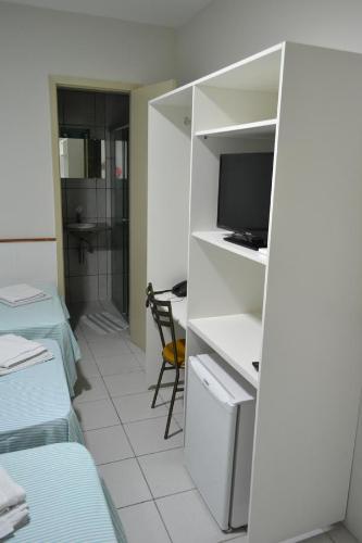 特雷西纳Hotel Itapoã的客房设有一张床、一张书桌和电视