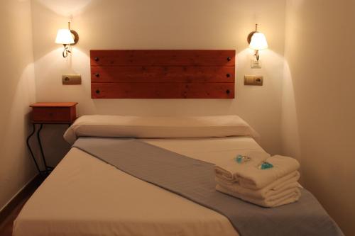 特鲁埃尔阿曼特斯德特鲁埃尔旅馆的带三张床的客房,床上配有毛巾