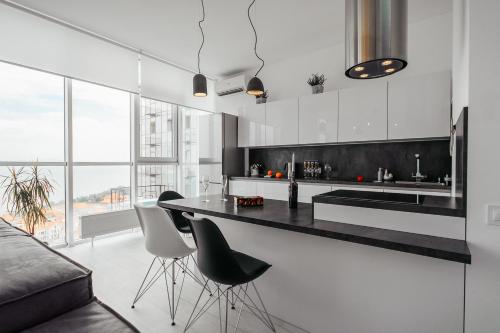 敖德萨Sea and Sky Apartment的厨房配有黑色柜台和白色橱柜