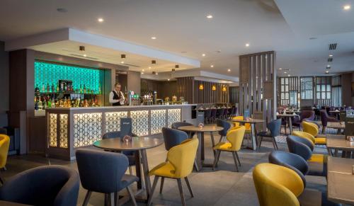 都柏林皮尔斯街马德龙酒店的一间带桌椅的餐厅和一间酒吧