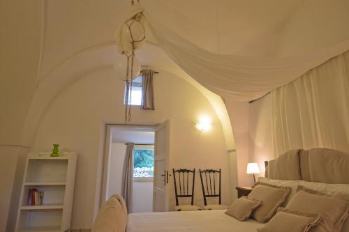 圣维托诺曼Masseria Pagliamonte Ortensia的卧室配有白色床和天花板
