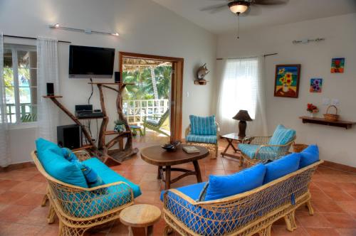 圣佩德罗Caye Casa的客厅配有蓝色的家具和电视